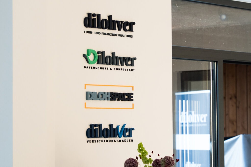Bürowand mit aufgedruckten Firmenlogos und Branding