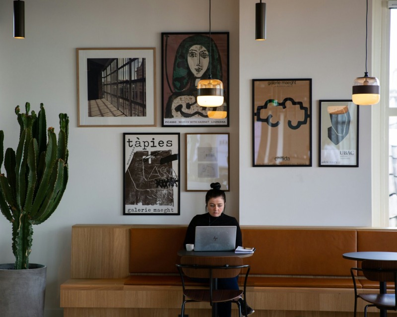 Person arbeitet am Laptop in einer stilvoll eingerichteten Empfangslounge